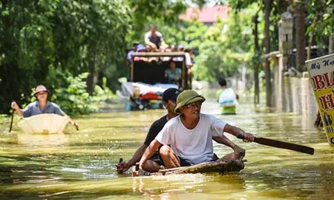 Hơn 800 hộ ở Hà Nội vẫn bị cô lập trong nước lũ, dân bơi trước cửa nhà